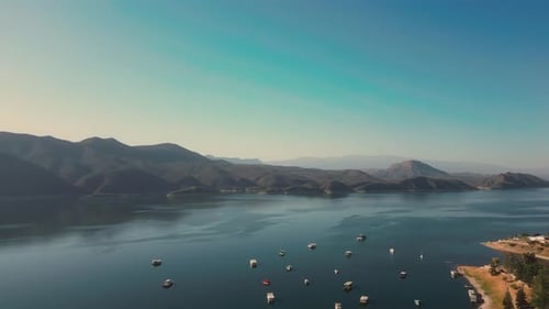 Aerial drone flying over a lake, water dam, with mountains at sunrise. Beautifull dreamy landscape.