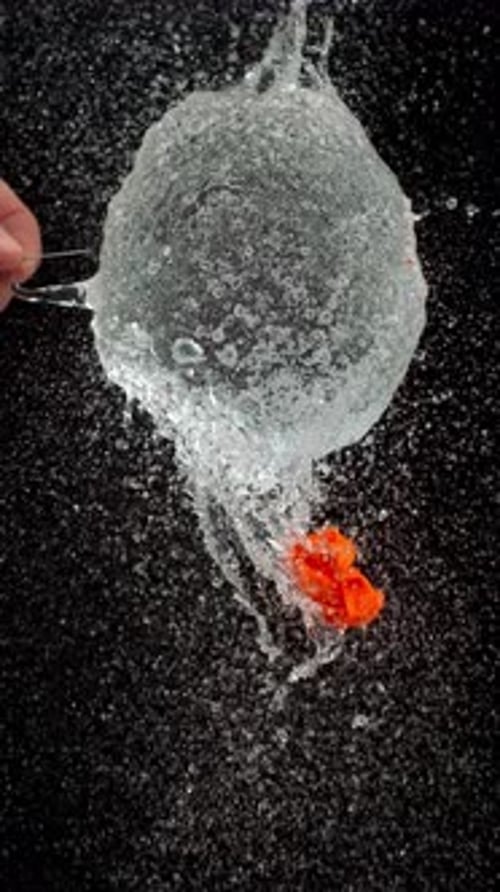 Water Balloon Explosion in Slow Motion Against Black