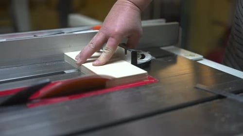 Skilled Craftsman Meticulously Trims Furniture Edges Using Safety Tools And Guides At Workshop Table