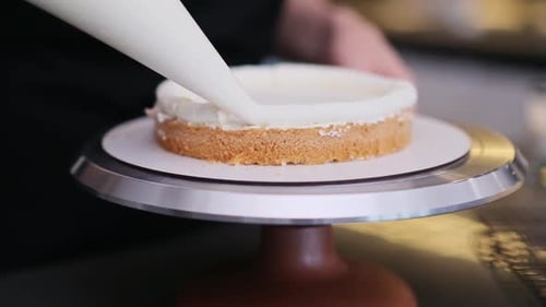 Chef Decorates Cake with Creamy White Icing