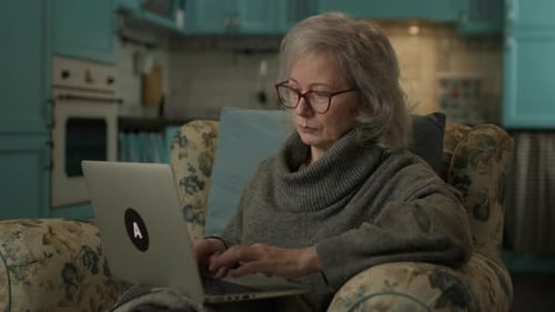 60s Woman Using Laptop At Home