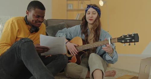 Young Adult Playing Guitar in a Home