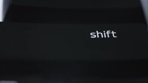 Pressing the shift button on black computer keyboard