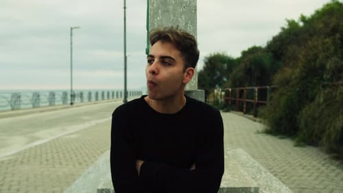 Boy Eats Yummy Food Sitting In A Park Outdoors In Cloudy Day