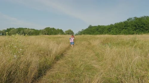 Joyful Preadolescent Girl in Superhero Costume and Mask Running on Field