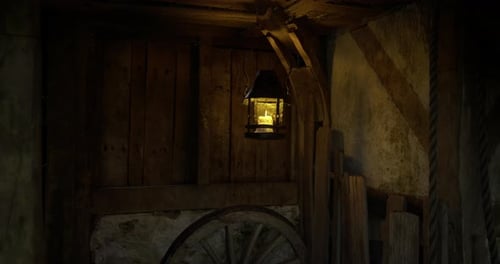 Soft Glow of Lantern Illuminating Rustic Wooden Cabin Interior in the Evening