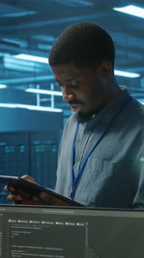 Vertical Video IT Specialist in Server Farm Ensuring Valuable Data Remains Shielded