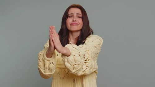 Young Woman Begging and Pleading With Clasping Hands