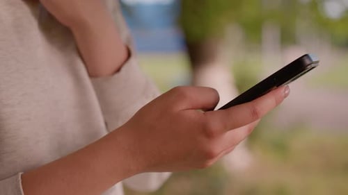 CloseUp of Hands Operating Smartphone Outdoors