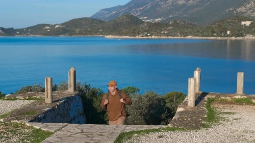 Tourist Arriving at Scenic Overlook Raising Arms in Triumph