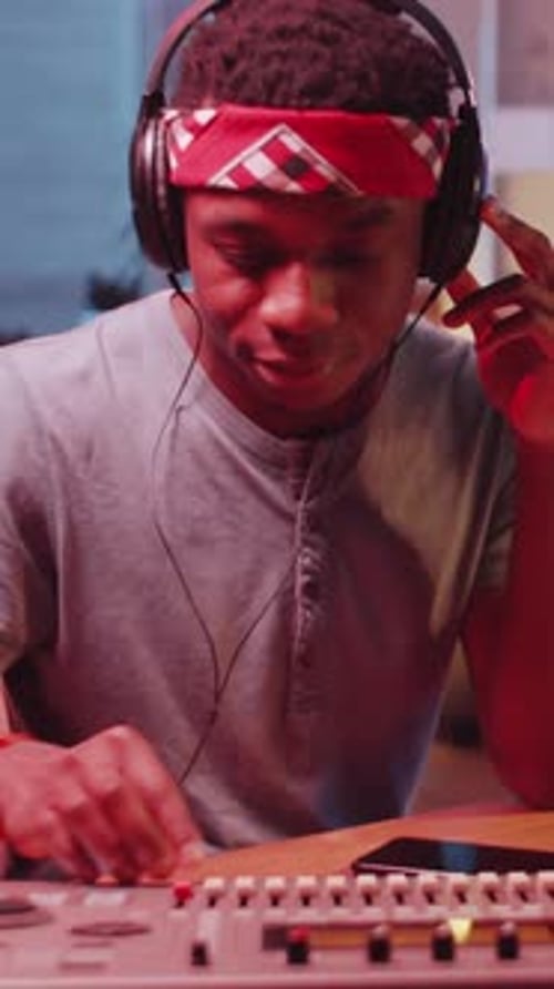 Black Musician Using Soundboard in Home Recording Studio
