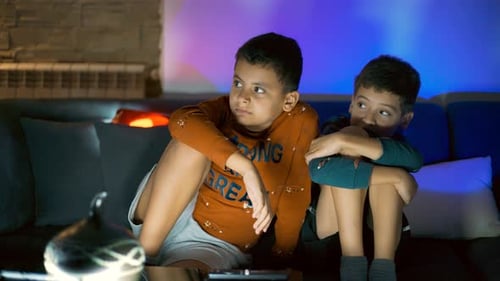 Two Boys Watching Television at Night on Couch