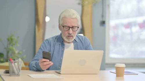 Senior Man Using Smartphone at Home