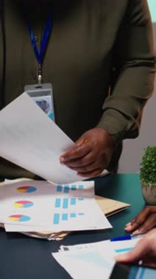Vertical Video Diverse Team Members Meeting After Hours to Share Data Reports