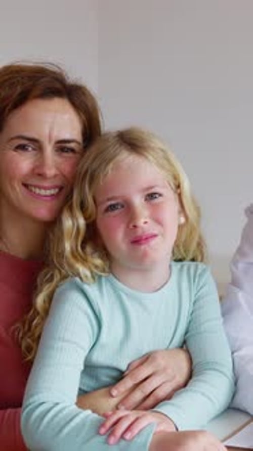 Portrait of Doctor and Little Girl with Her Mother Smiling at Camera at Clinic
