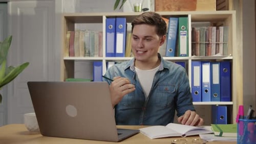 Young Adult Working on Laptop in Home Office