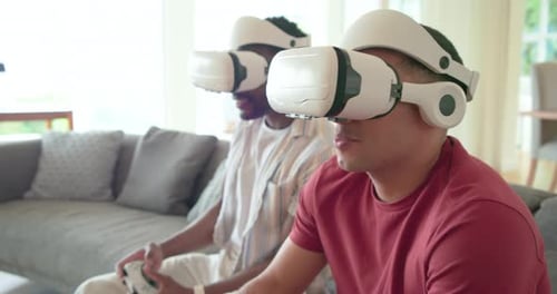 With game starting, Diverse male friends using VR headsets and controllers playing in living room