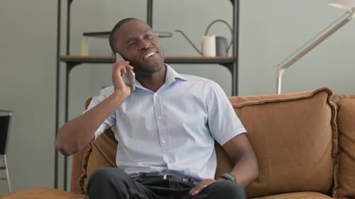Man Talking on Cell Phone on Sofa