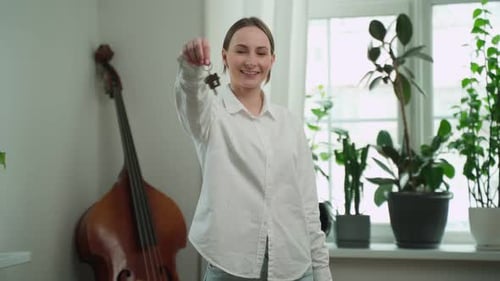 Woman Holding Keys to New Apartment