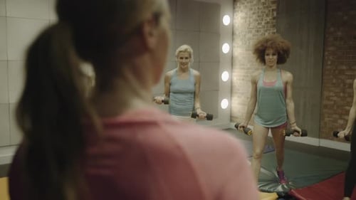 Group of adult women exercising with weights in gym