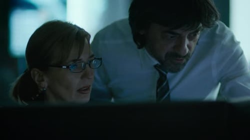 Colleagues work together in dimly lit office at night
