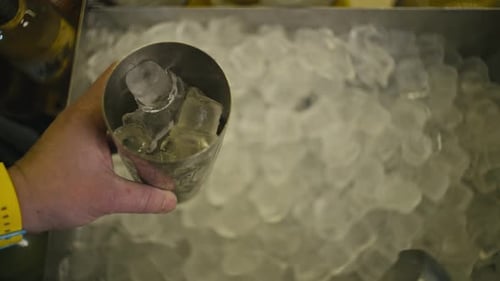 Filling Cocktail Shaker with Ice Cubes in Bar