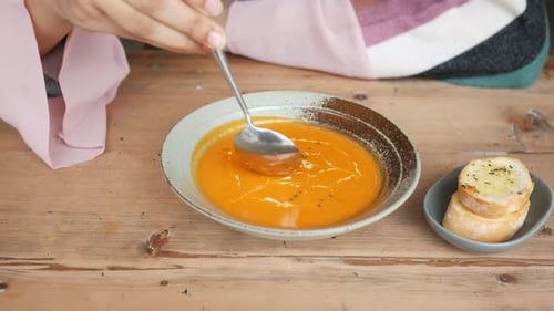 Stirring a Bowl of Yellow Vegetables Soup