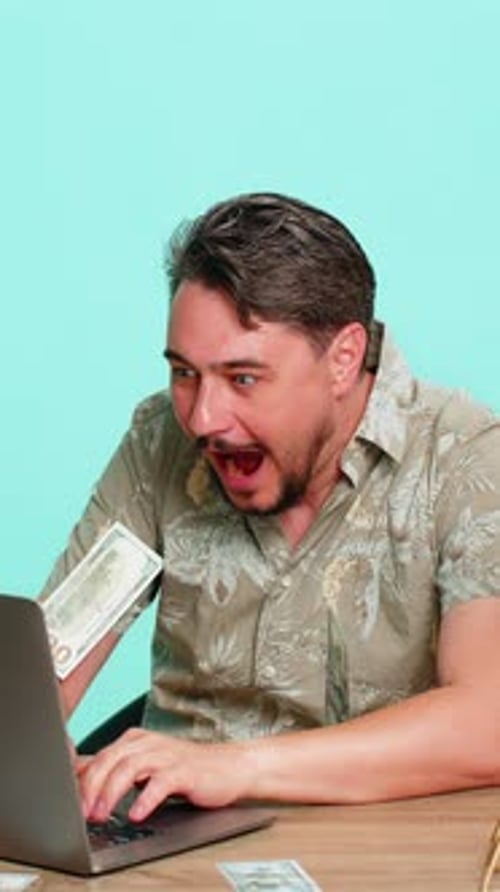 Man Using Laptop Celebrates With Money