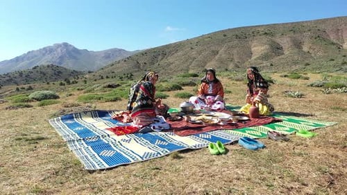 Vue aérienne de femmes et de filles vêtues de vêtements traditionnels mangeant sur la montagne