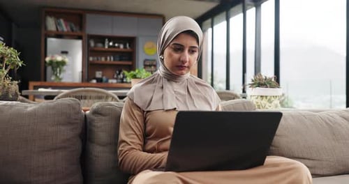 Woman in Headscarf Works on Laptop at Home