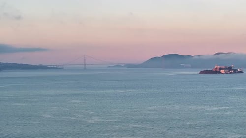 Wide aerial view of Alcatraz Island and Golden Gate Bridge, USA at Sunrise.