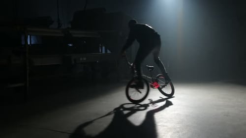 Young bmx rider performs thrilling freestyle tricks in an urban warehouse