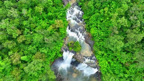 Aerial view over a waterfall in a beautiful tropical forest.