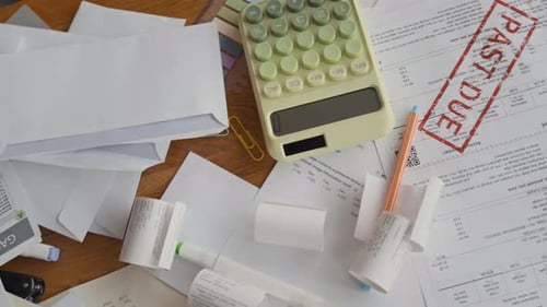 Past Due Bills and Calculator on Table for Financial Management