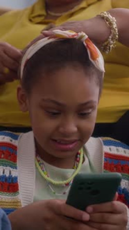 Child Gets Hair Styled While Looking At Phone