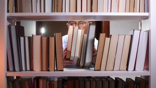 Young Adult Browsing Books on Bookshelf