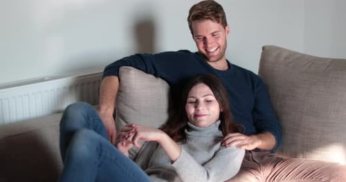 Couple relaxing on sofa at home