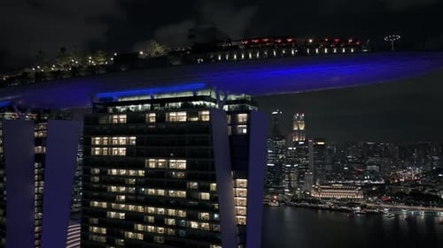 Close-up and baking away from Marina Bay Sands during night in Singapore, drone view