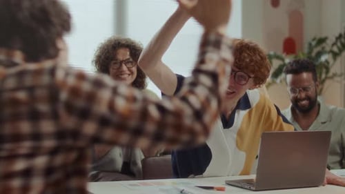 Happy Man Celebrating Achievement with Team of Colleagues in Office