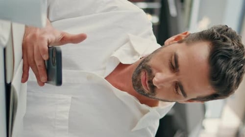 Focused Man Writing Notebook at Cafe Table Vertically Closeup Guy Holding Phone