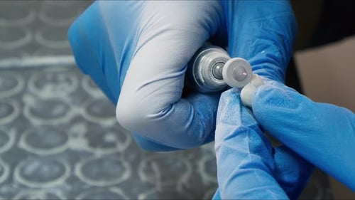 Dental Technician Shaping False Tooth with Grinding Tool