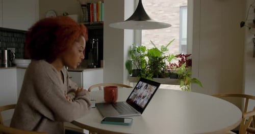 Woman Attends Online Meeting at Kitchen Table