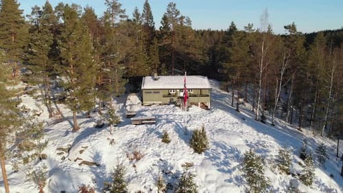 Winter Cabin in Snowy Forest Aerial View