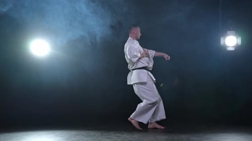 Man in Gi Practicing Karate Moves in Studio