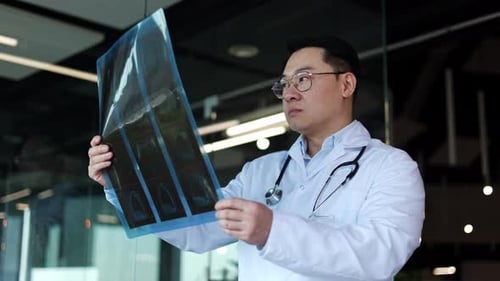 Orthopedist Examining Xray Picture and Determining Diagnosis in Office Room
