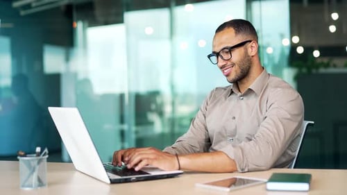 happy handsome business man working laptop computer at workplace in office desk. Male typing,