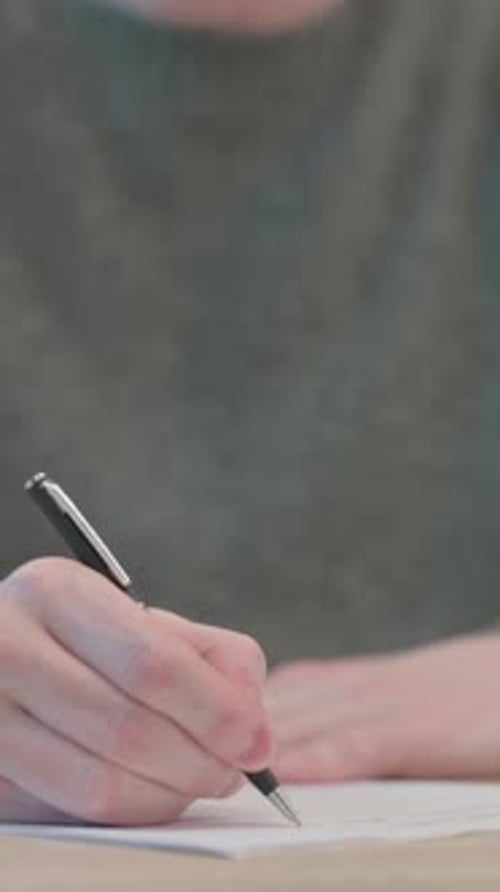 Close up of Hands of Man Writing on Paper, Vertical Video