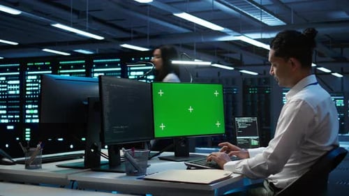 System Administrator Overseeing Data Center Using Green Screen Computer