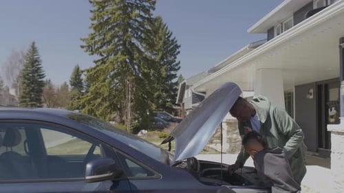 Un père enseigne à son fils les bases du moteur de voiture