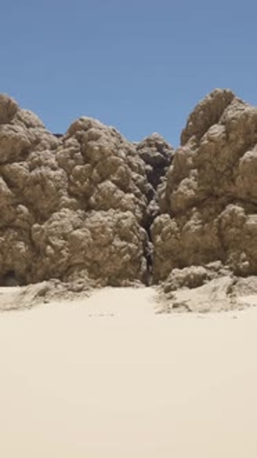 A Group of Rocks Sitting on Top of a Sandy Beach